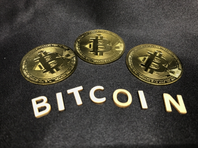 黒背景の上にあるビットコイン、仮想通貨イメージ